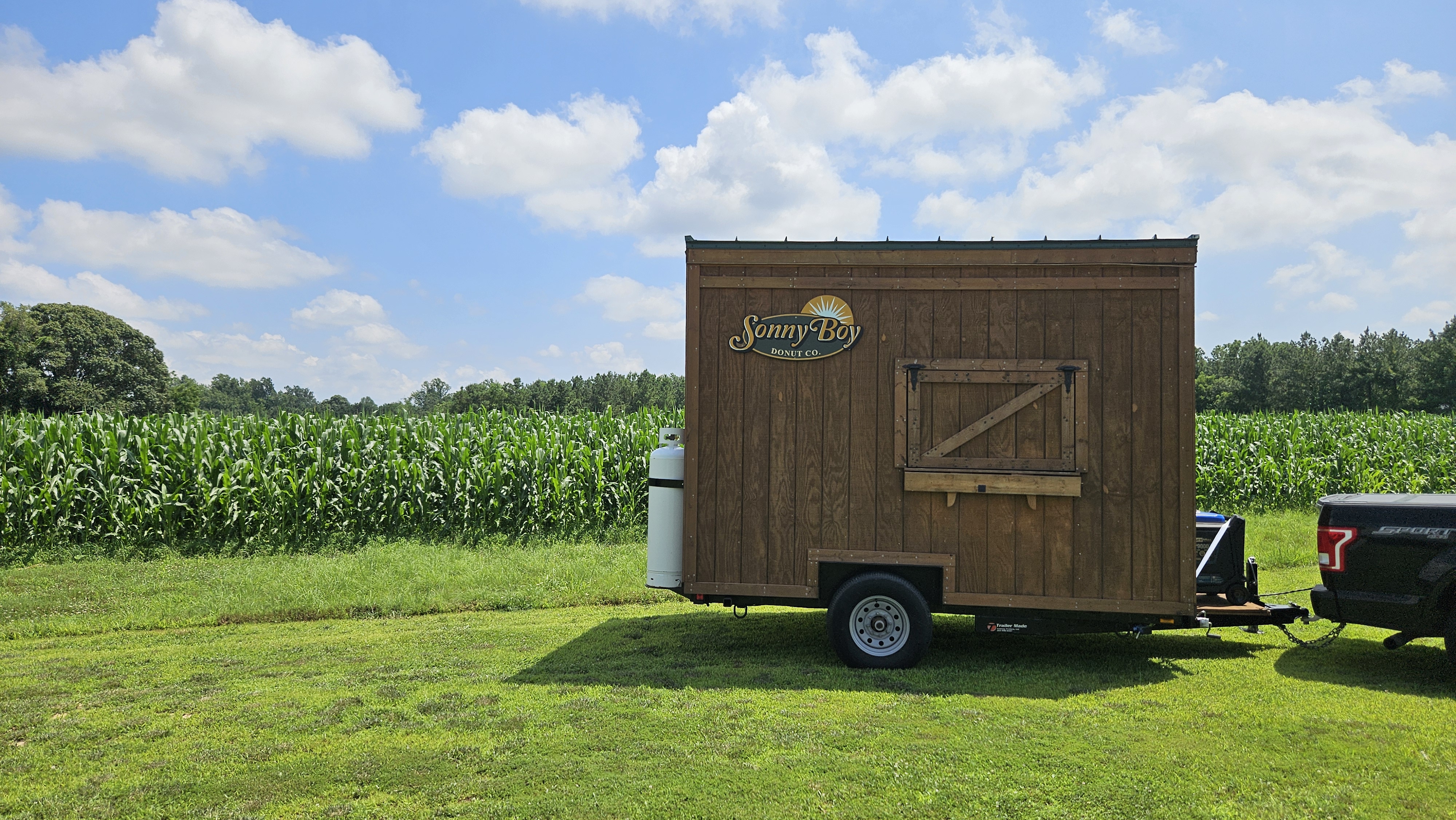 Sonny Boy Donut Co. trailer parked next to a cornfield